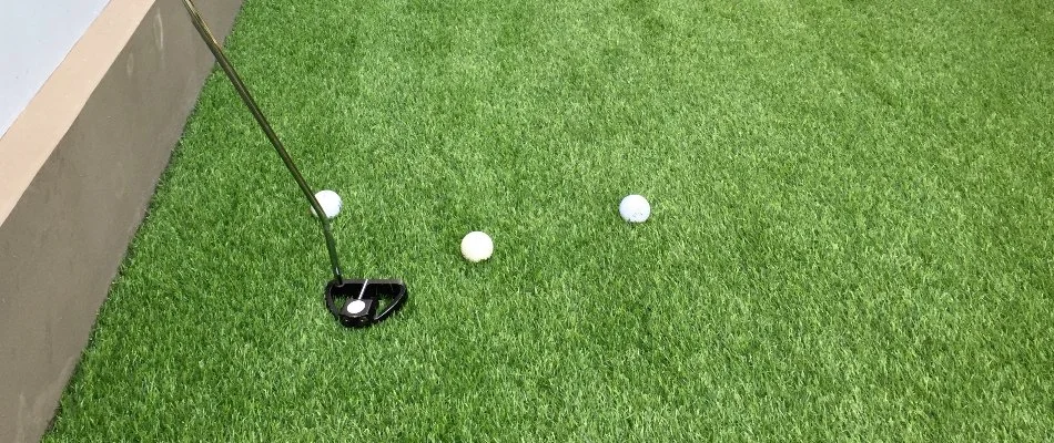 Artificial turf in Waukee, IA, with golf putter and balls.