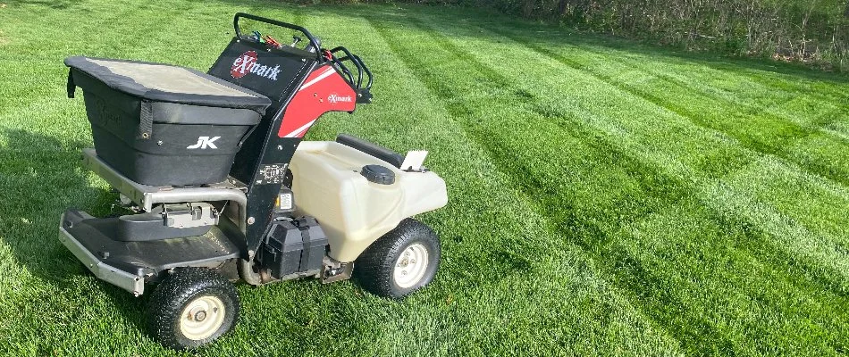 A healthy lawn in Waukee, IA, with fertilizer equipment.