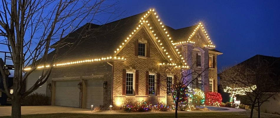 House in Waukee, IA, with white and colored Christmas lights.
