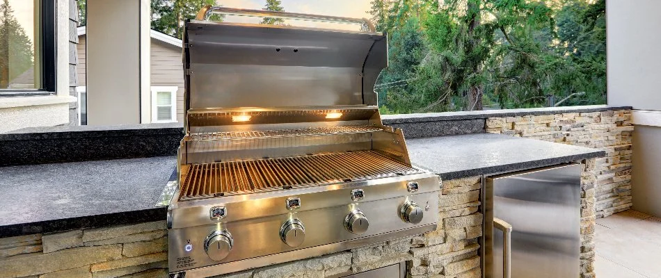 Outdoor kitchen in Waukee, IA, with grill and fridge.
