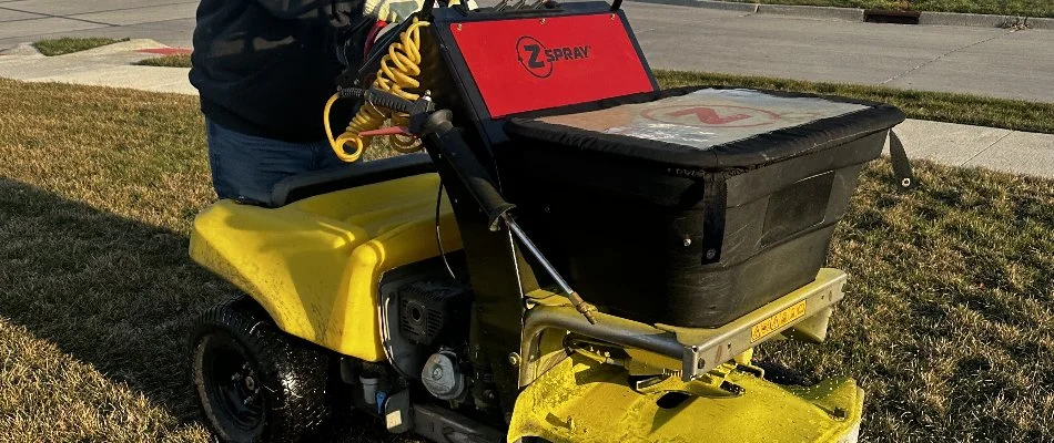 Tech using fertilizer equipment on a lawn in Waukee, IA.