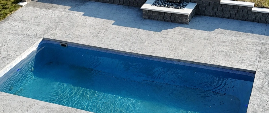 Concrete patio installation in front of a house, providing a durable and functional outdoor space in Waukee, IA.