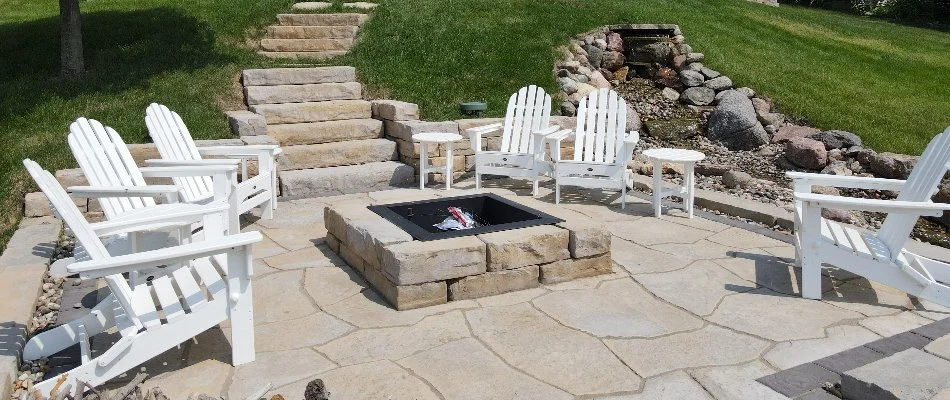 Outdoor living space with fire pit and stairs in Windsor Heights, IA.