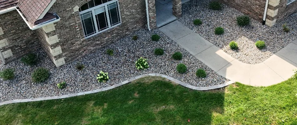 Grass and rock landscape in Lovington, IA, with small shrubs.
