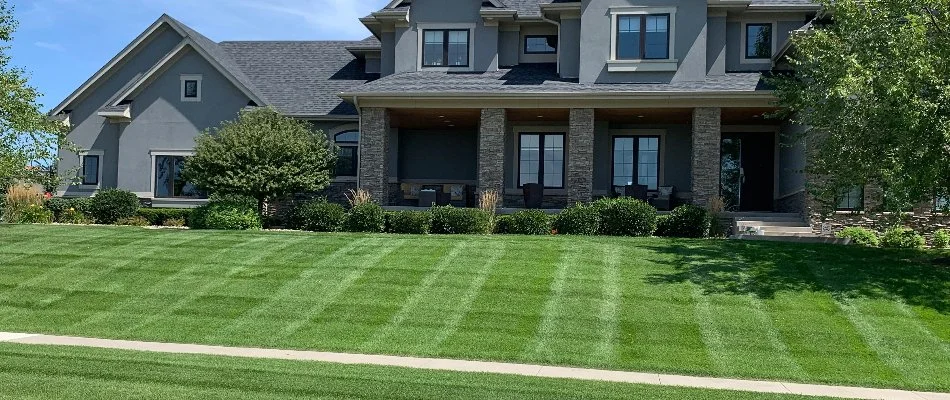 House with neatly mowed striped lawn.