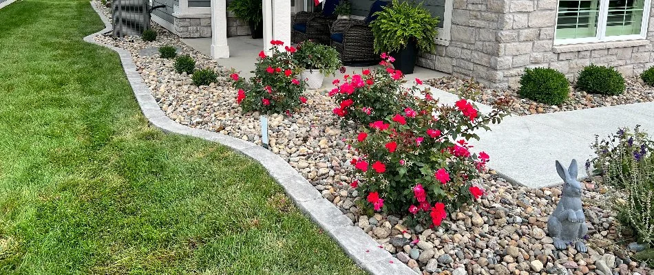 Landscape bed in Avon, IA, with rocks and flowers.