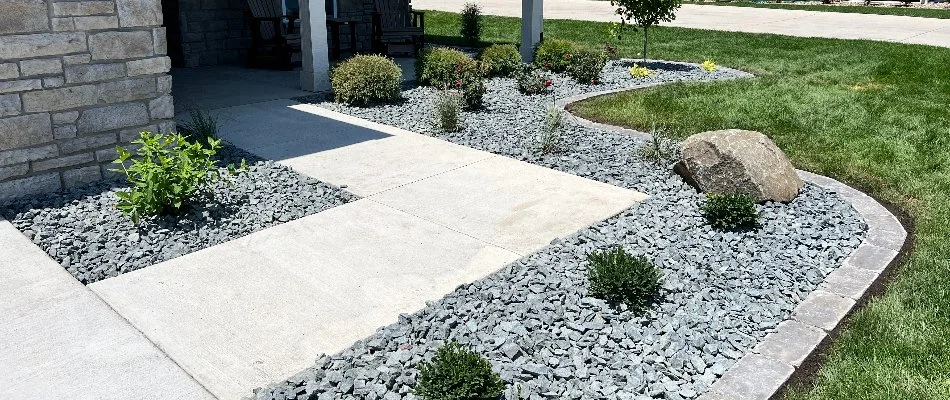 Landscape bed in Waukee, IA, with rocks and plants.