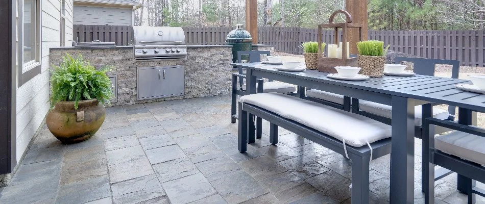 Outdoor kitchen with a grill, green egg, and table on a property in Waukee, IA.