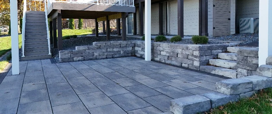 A paver patio in Waukee, IA, with a matching retaining wall and steps.