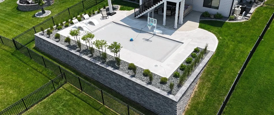 Retaining wall and pool in Carlisle, IA, with landscaping.