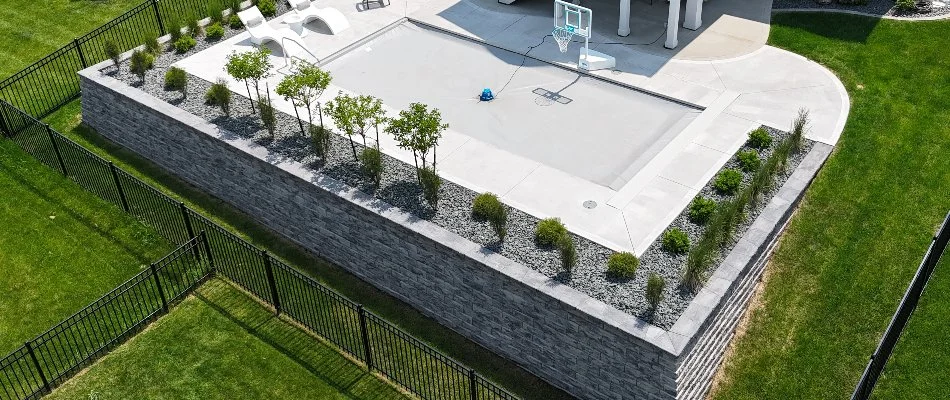 Retaining wall in Norwoodville, IA, with pool and landscaping.
