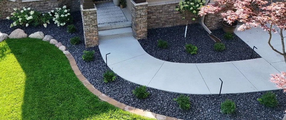 Rocks and shrubs around a concrete walkway in Dallas Center, IA.